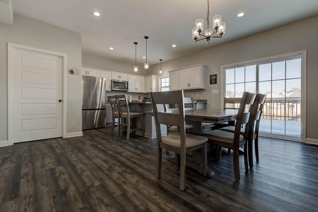 dining room featuring dark wood-type flooring, a chandelier, and a healthy amount of sunlight