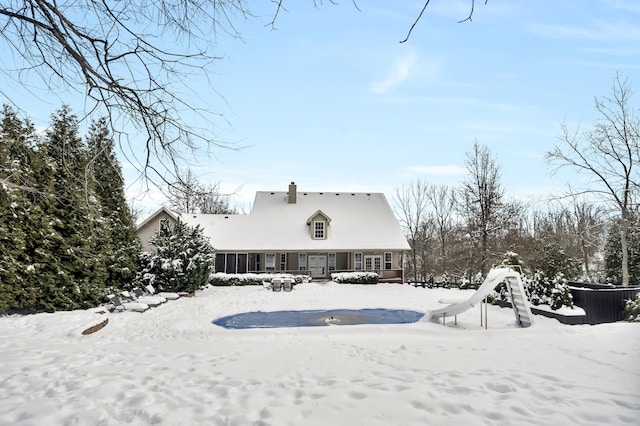 view of snow covered rear of property