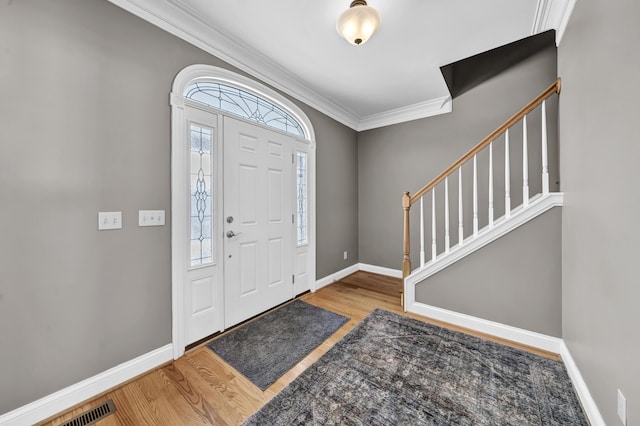 foyer featuring crown molding and hardwood / wood-style flooring