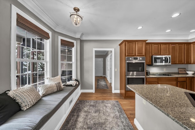 kitchen featuring crown molding, stainless steel appliances, stone countertops, and a notable chandelier