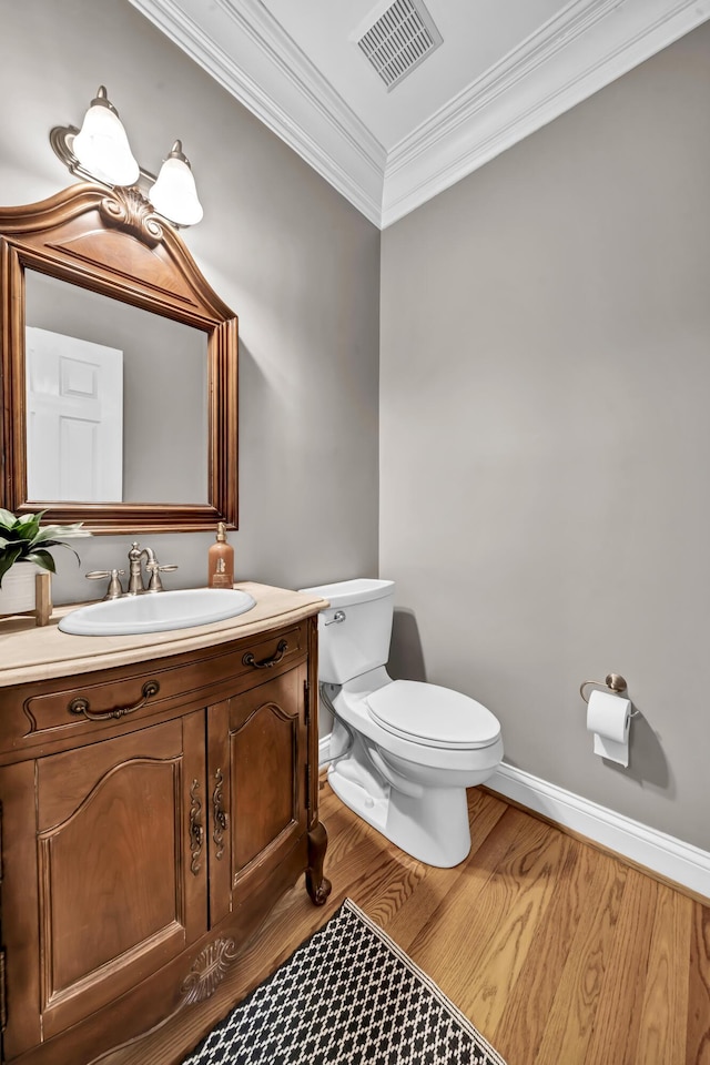 bathroom featuring vanity, toilet, wood-type flooring, and crown molding