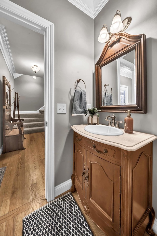 bathroom featuring crown molding, vanity, and hardwood / wood-style flooring