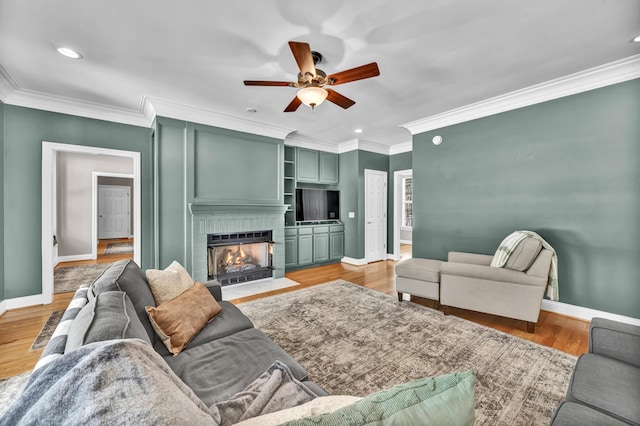 living room with light wood-type flooring, ceiling fan, and ornamental molding