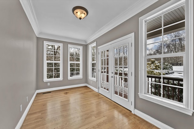 doorway featuring crown molding, french doors, and light wood-type flooring