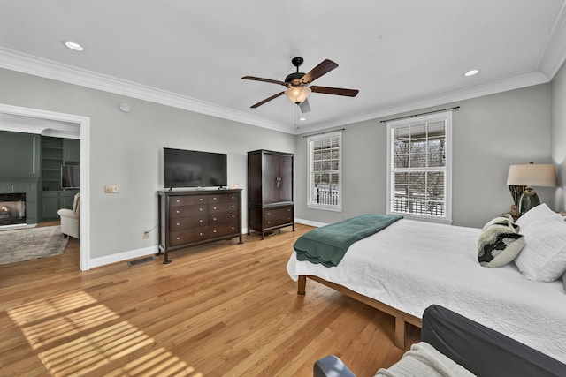 bedroom with light hardwood / wood-style flooring, ceiling fan, and ornamental molding