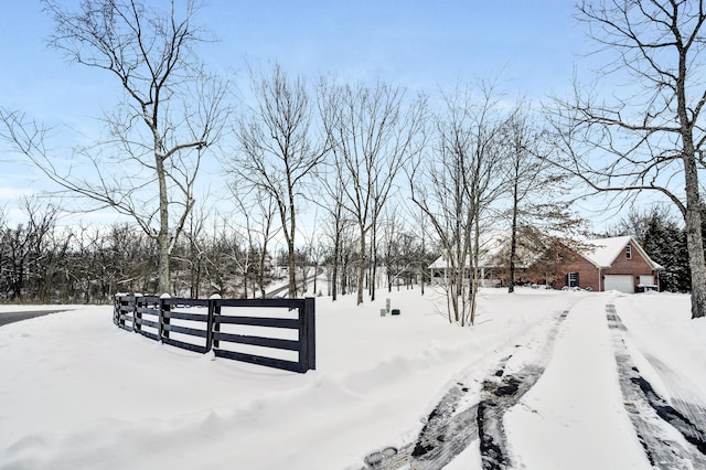 yard covered in snow featuring a garage