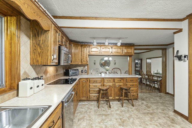 kitchen featuring appliances with stainless steel finishes, backsplash, a textured ceiling, and ornamental molding