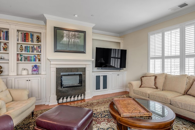 living room with built in shelves and ornamental molding