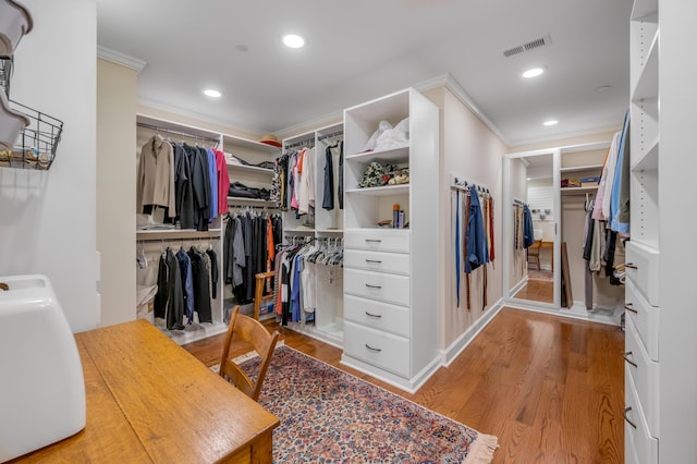 walk in closet with light hardwood / wood-style flooring