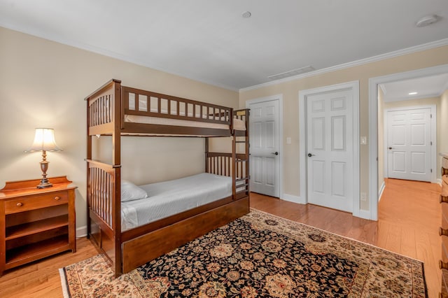 bedroom with light hardwood / wood-style floors and crown molding