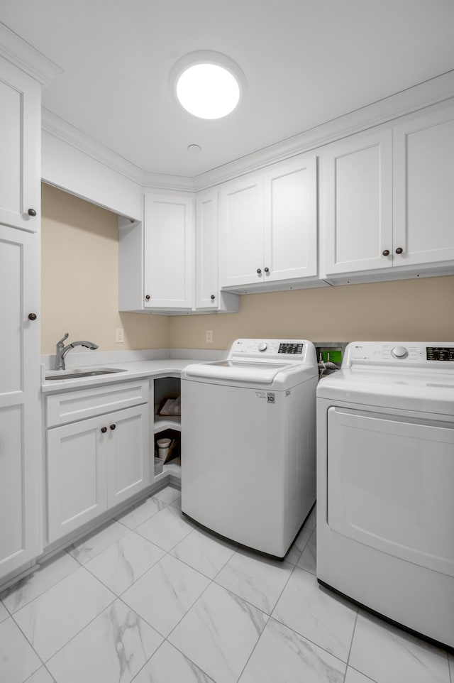 laundry room with washer and dryer, cabinets, and sink