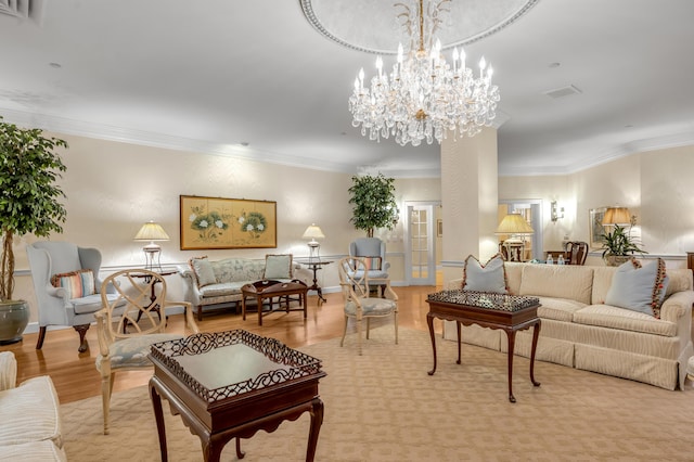 living room featuring hardwood / wood-style flooring, a chandelier, and ornamental molding