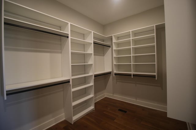 spacious closet with dark wood-style flooring and visible vents