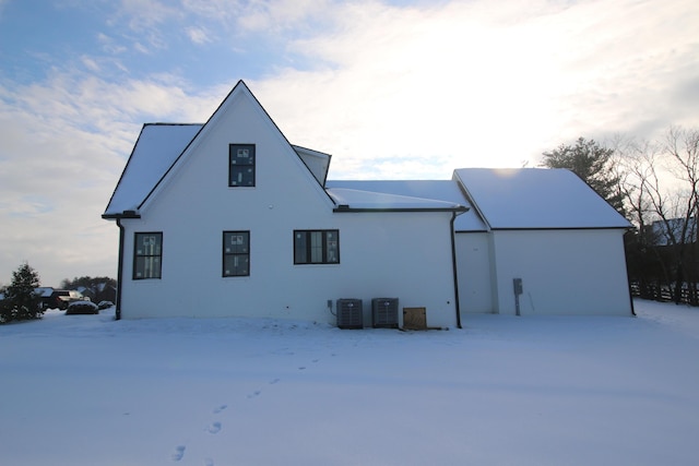 snow covered back of property with cooling unit