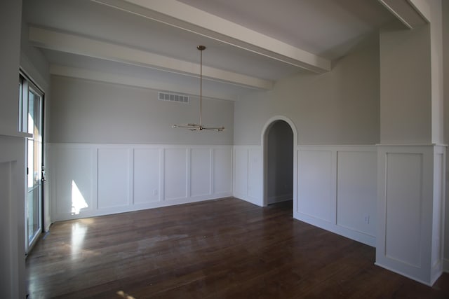 unfurnished dining area with beam ceiling, dark wood finished floors, wainscoting, visible vents, and arched walkways