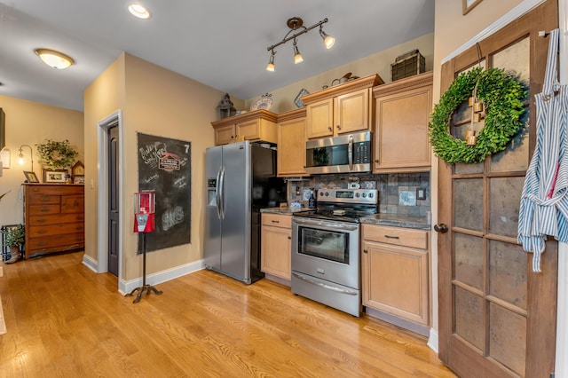 kitchen with appliances with stainless steel finishes, decorative backsplash, light hardwood / wood-style flooring, and light brown cabinets