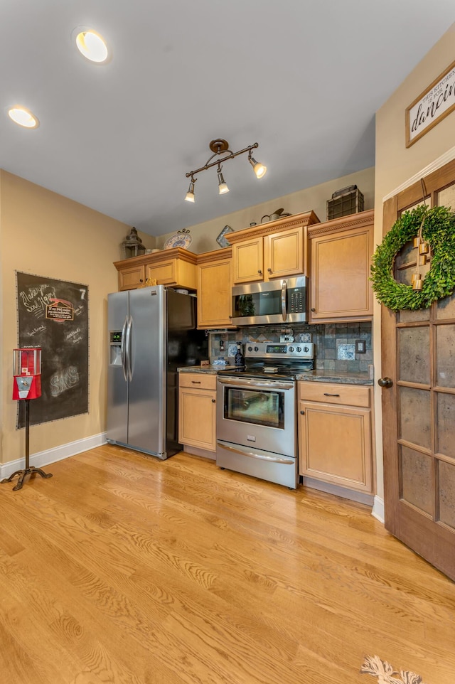 kitchen featuring backsplash, appliances with stainless steel finishes, light brown cabinets, and light hardwood / wood-style floors