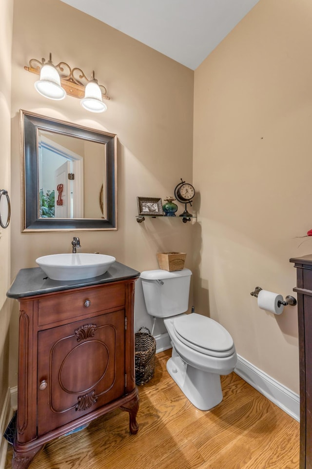 bathroom featuring toilet, wood-type flooring, and vanity