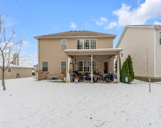 snow covered rear of property featuring a porch