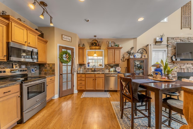 kitchen featuring decorative light fixtures, backsplash, sink, and stainless steel appliances