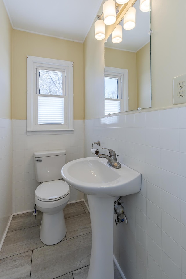 bathroom featuring tile walls, plenty of natural light, and toilet