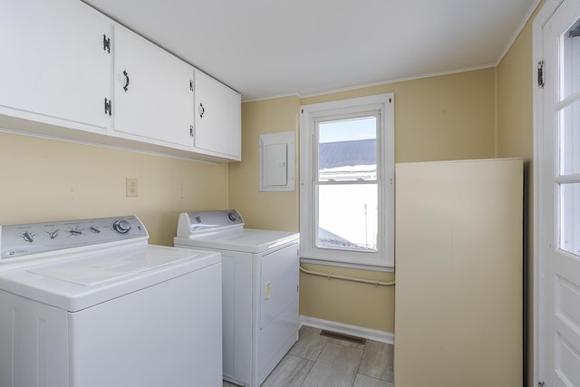 laundry area with washer and dryer, crown molding, electric panel, and cabinets