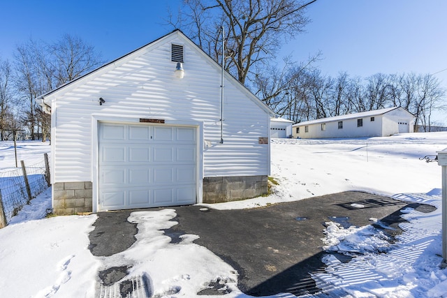 view of snowy exterior with a garage