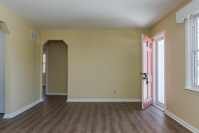 spare room with dark hardwood / wood-style flooring and a wealth of natural light