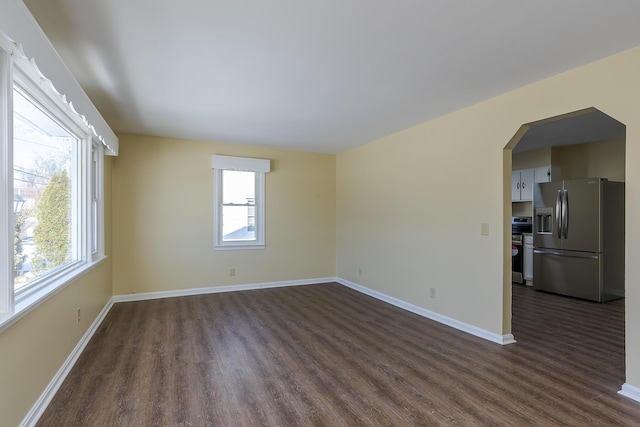 unfurnished room featuring a healthy amount of sunlight and dark wood-type flooring