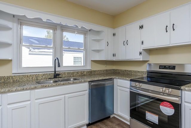 kitchen featuring dark hardwood / wood-style flooring, white cabinets, dark stone counters, appliances with stainless steel finishes, and sink