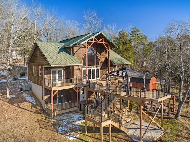 rear view of house featuring a gazebo, central AC unit, and a wooden deck