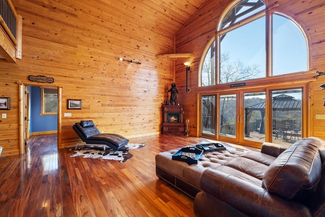 living room with wood-type flooring, high vaulted ceiling, wooden walls, and wood ceiling