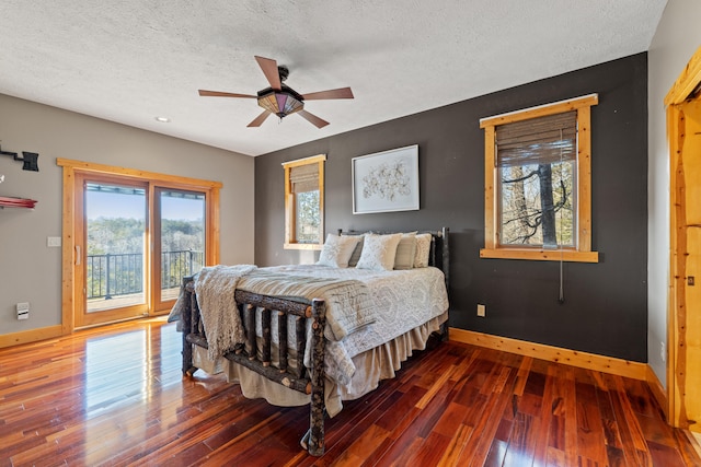 bedroom with dark hardwood / wood-style flooring, a textured ceiling, ceiling fan, and access to exterior