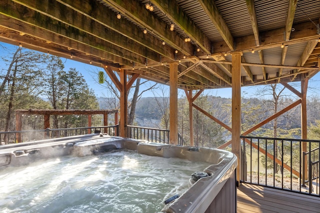 deck with a mountain view and a hot tub