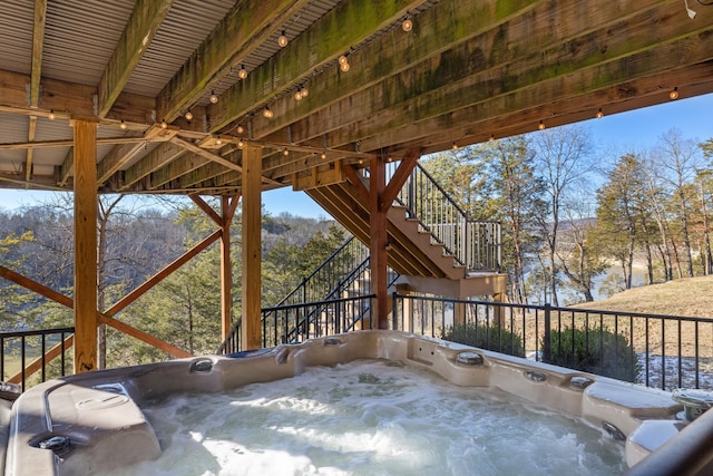 view of patio featuring a hot tub and a water view