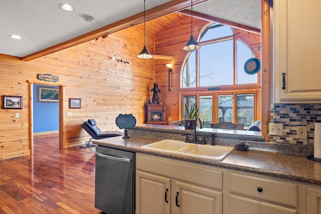 kitchen featuring sink, decorative light fixtures, dishwasher, hardwood / wood-style flooring, and wood walls