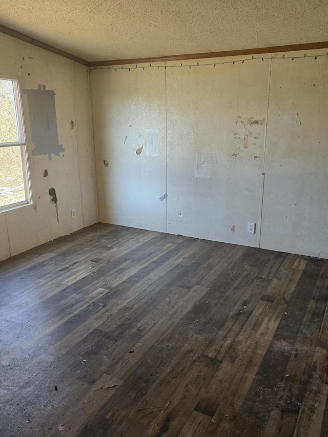 unfurnished room featuring dark wood-type flooring and a textured ceiling