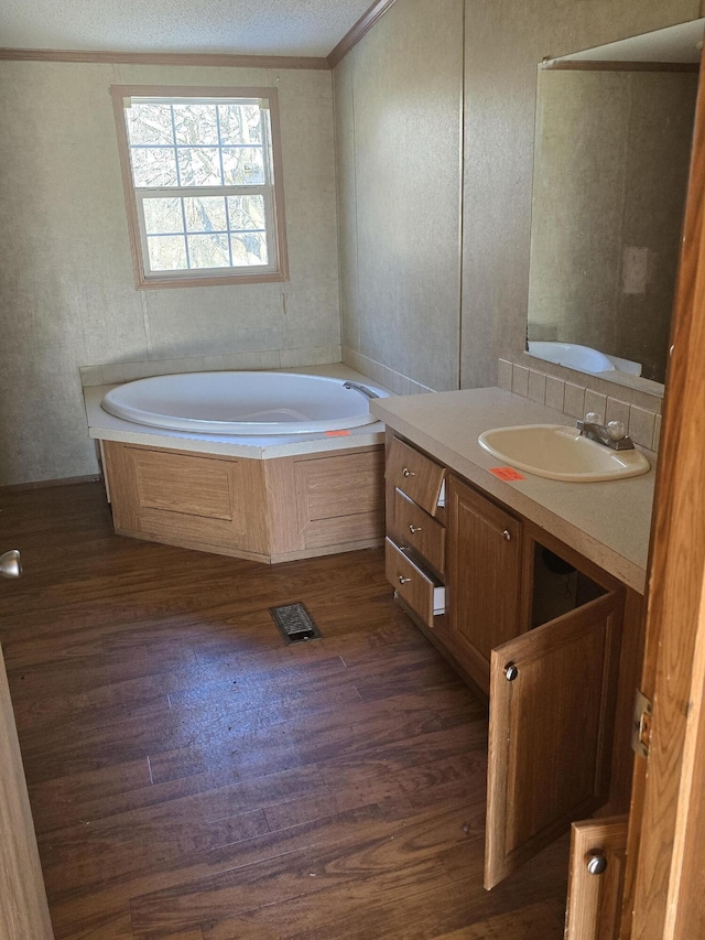 bathroom featuring hardwood / wood-style floors, a bathtub, vanity, and crown molding