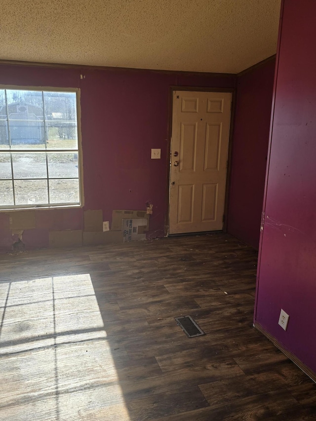 interior space featuring a textured ceiling and dark hardwood / wood-style floors