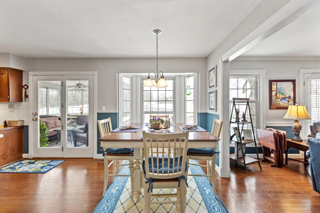 dining space featuring ceiling fan with notable chandelier and dark hardwood / wood-style flooring