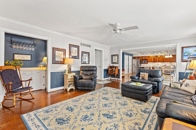 living room with ceiling fan with notable chandelier, ornamental molding, and dark hardwood / wood-style floors