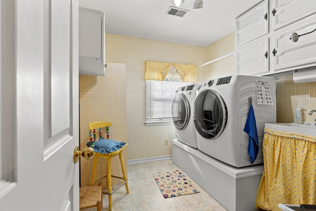 laundry area with washing machine and dryer and cabinets