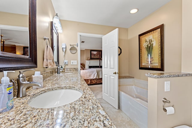 bathroom with a tub to relax in, vanity, and tile patterned floors