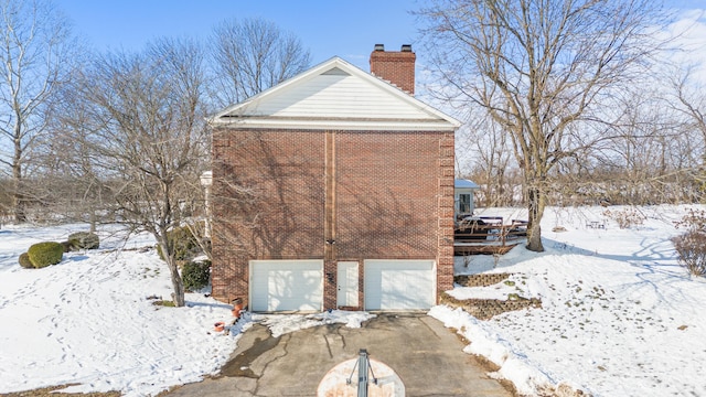 view of snowy exterior with a garage