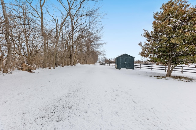 snowy yard with a storage shed