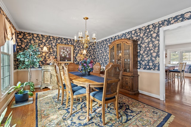 dining area featuring ornamental molding, hardwood / wood-style floors, and an inviting chandelier