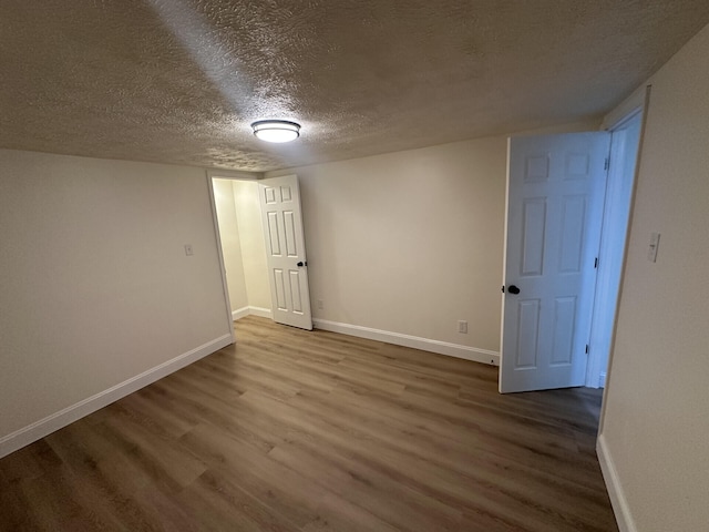 spare room with a textured ceiling and hardwood / wood-style flooring