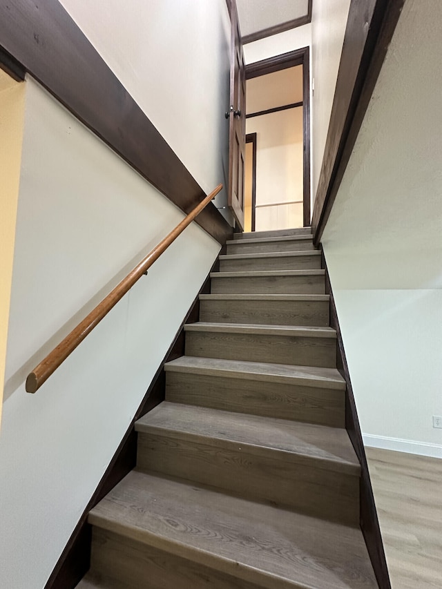 staircase with hardwood / wood-style floors