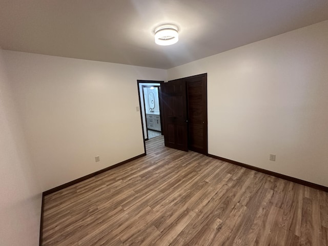 unfurnished bedroom featuring a closet and hardwood / wood-style flooring