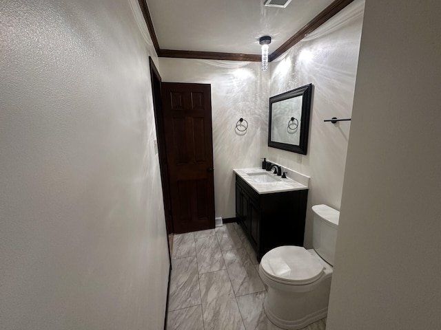 bathroom with ornamental molding, vanity, and toilet